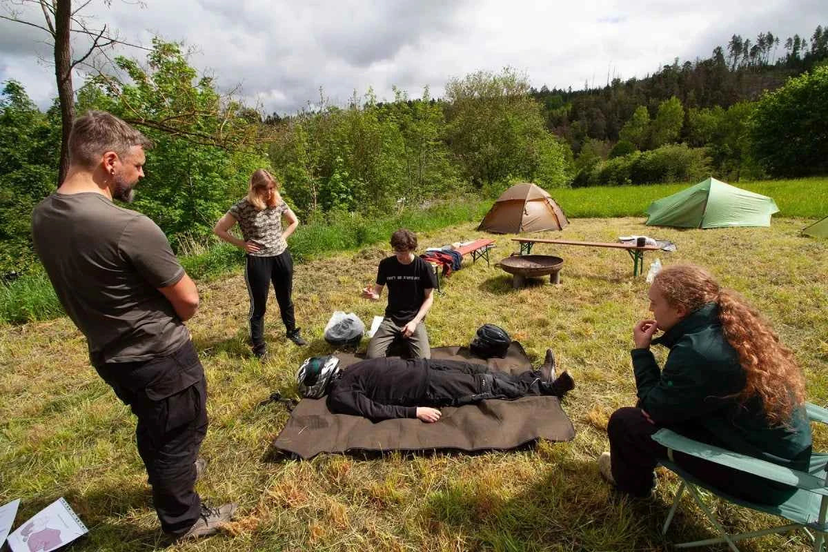 Praktische Übung zur Helmabnahme nach einem Motorradunfall bei einem Outdoor Erste-Hilfe-Kurs in Deutschland